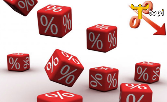 Hình ảnh hai người đang thảo luận với máy tính và tài liệu, tượng trưng cho việc phân tích cách tính lãi suất vay ngân hàng và lựa chọn phương án vay phù hợp.