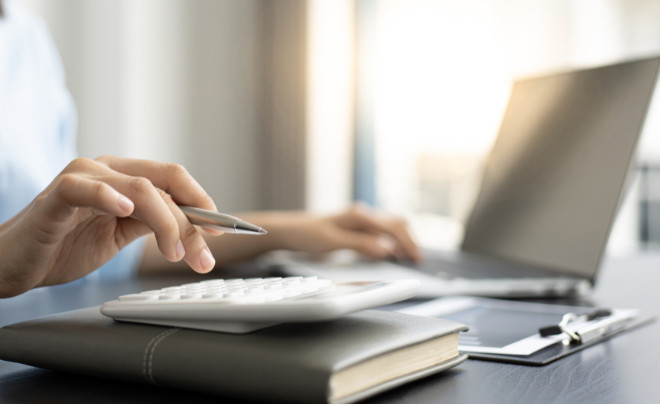 Một người đang cân nhắc chi tiêu của mình, thể hiện việc kiểm soát các khoản tiền ăn vặt không cần thiết tại nơi làm việc