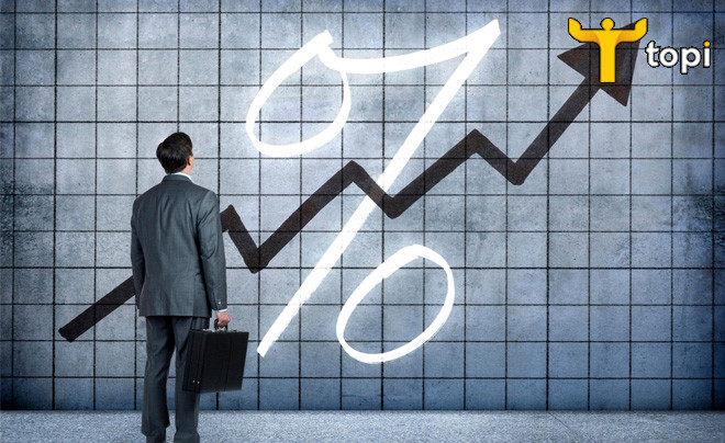 Một người phụ nữ trẻ đang xem xét các con số tài chính trên máy tính, biểu thị việc tìm hiểu cách tính lãi suất vay ngân hàng và các khái niệm liên quan.