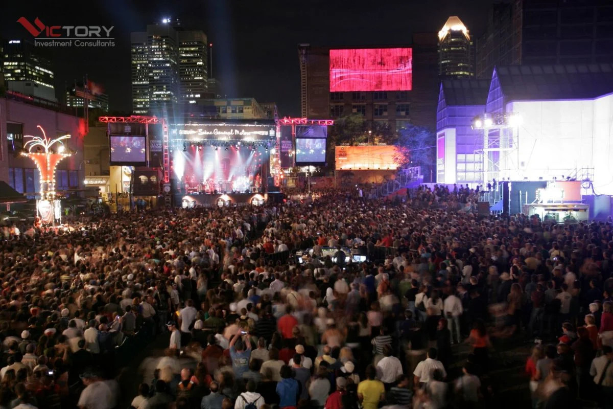 Quang cảnh đêm rực rỡ của khu phố giải trí Montreal với ánh đèn và dòng người, cho thấy cuộc sống về đêm sôi động.