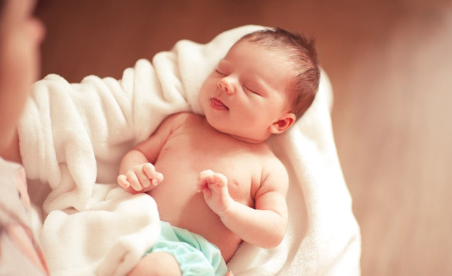 Tã bỉm em bé và sữa công thức trên bàn gỗ, biểu trưng cho chi phí nuôi trẻ sơ sinh