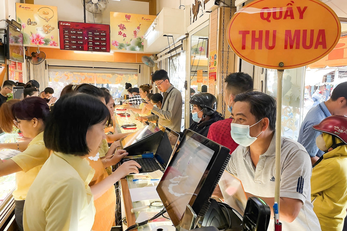 Khách hàng giao dịch tại tiệm vàng trong ngày vía Thần Tài, thể hiện nhu cầu đầu tư và mua sắm vàng dịp lễ, ảnh hưởng đến giá vàng
