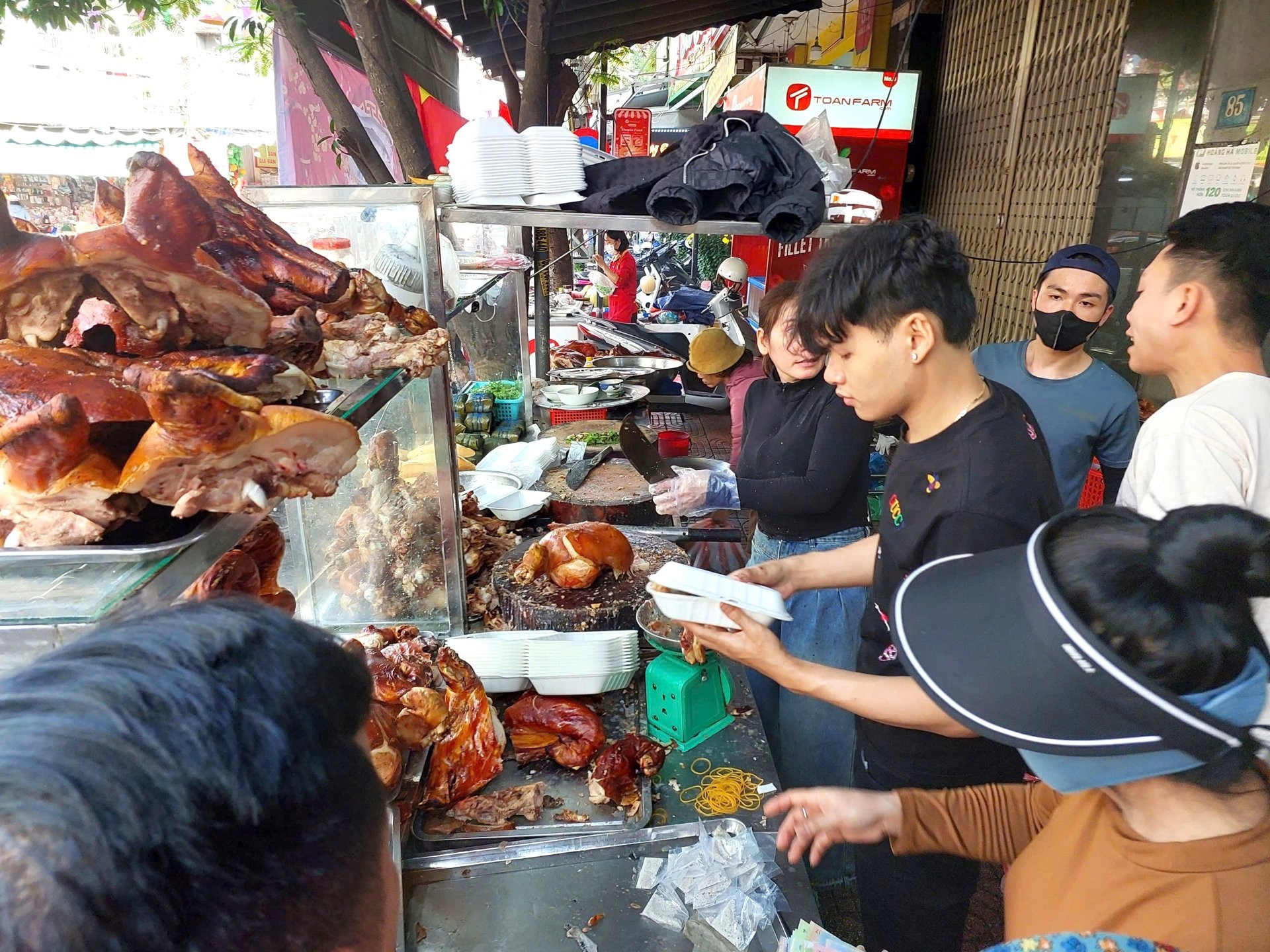 Một quầy heo quay đông đúc khách hàng tại Đà Nẵng, thể hiện nhu cầu cao về các món cúng truyền thống ngày Vía Thần Tài.