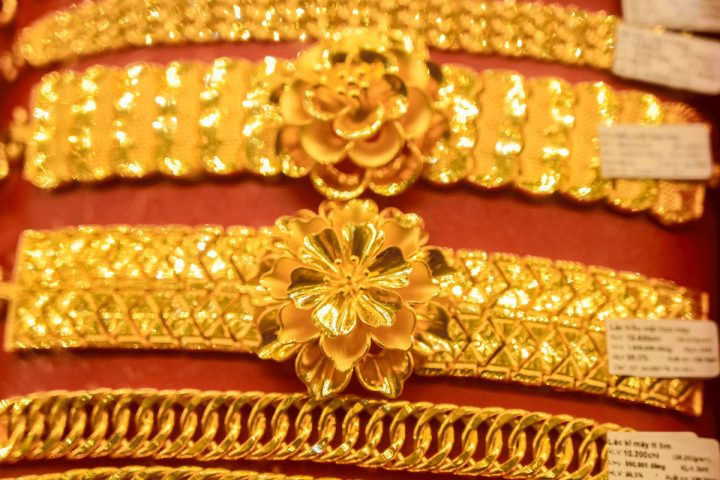 Người dân quan sát biểu đồ giá vàng tại cửa hàng, phản ánh biến động giá kim loại quý