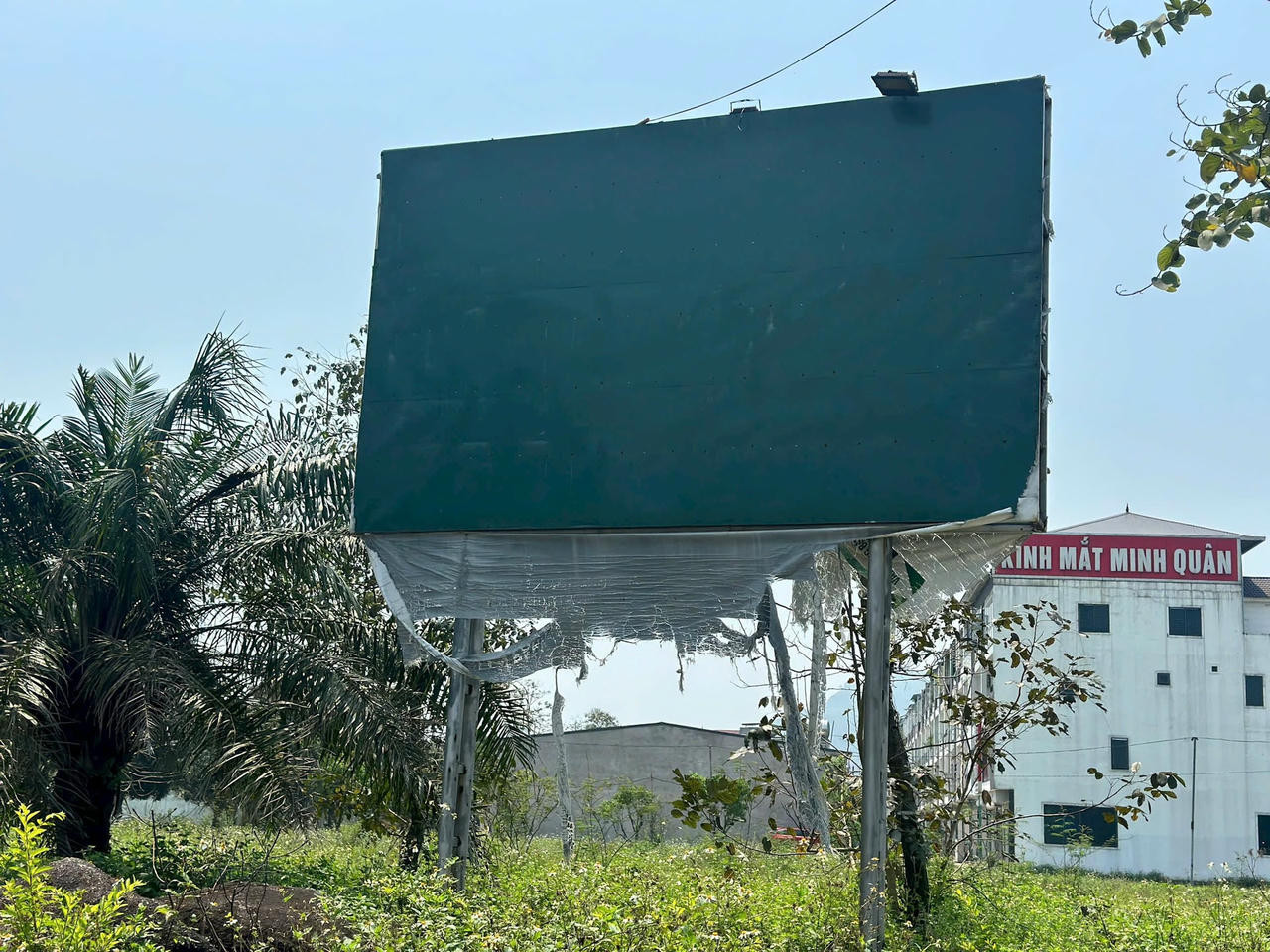 Bảng quảng cáo quy hoạch Khu đô thị Xuân An bị rách nát, tượng trưng cho sự xuống cấp và bỏ bê của dự án
